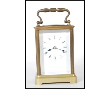 A 20th Century brass carriage clock of rectangular form having glass panels to the four sides with exposed mechanism to the b