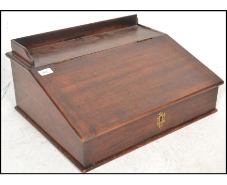 A Victorian 19th century mahogany clerks desk. The box shaped body with sloped and hinged top complete with gallery shelf ato