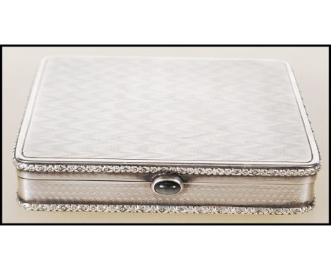 An early 20th Century continental silver cigarette case of square form having relief floral decorated borders with engine tur