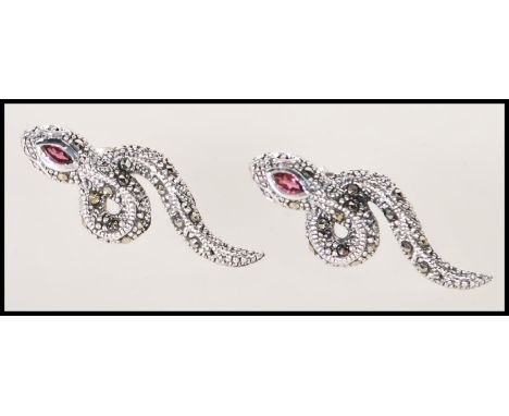 A pair of silver and marcasite set earrings in the form of snakes. Each one set with a single amethyst stone to the head. Sta