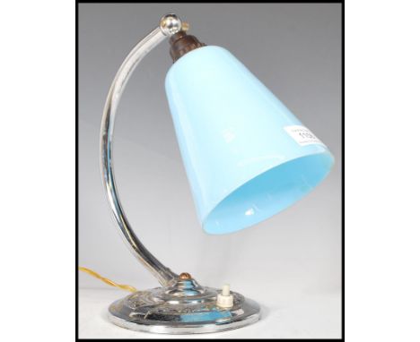 An early 20th Century Art Deco desk / table lamp, having a chrome circular base, chrome bend support and a conical blue glass