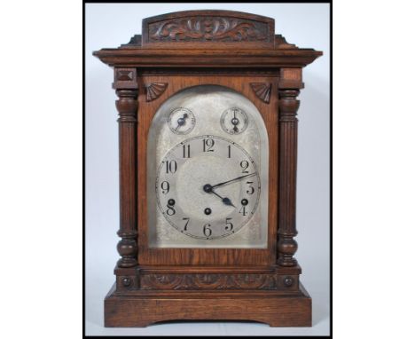 An early 20th century oak-cased eight-day quarter chime mantel clock by Kienzle, with engraved silvered Roman dial and subsid