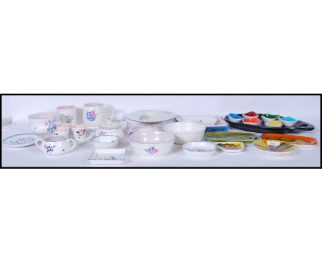 A large collection of Poole pottery to include abstract pin dishes, cups, dishes, creamers, condiments, egg cups. dishes, bow