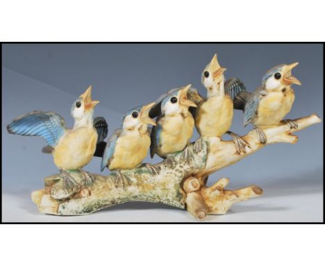 A 20th Century Italian ceramic bisque figurine group in the form of blue tit birds perched on a branch being hand painted. Ma