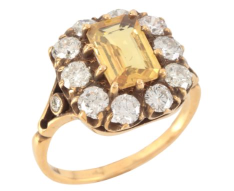 A YELLOW SAPPHIRE AND DIAMOND CLUSTER RINGin 18ct gold, set with a step cut yellow sapphire of c.1.67 carats, surrounded by a