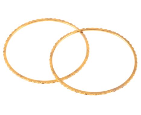 A PAIR OF GOLD BANGLESin high carat gold, with engine turned detail to the outside, no assay marks, internal circumference c.