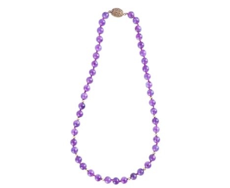 AN AMETHYST NECKLACEcomprising a series of amethyst beads of c.9.0mm, accented by gilt bead spacers, secured with a silver gi