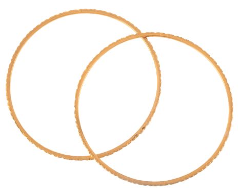 A PAIR OF GOLD BANGLESin high carat gold, with engine turned detail to the outside, no assay marks, internal circumference c.