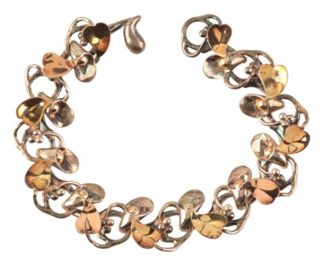 BRETT PAYNE: A 'FLOWER' BRACELETin sterling silver and 18ct yellow and rose gold, comprising a series of fancy links with lea