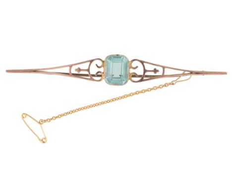AN AQUAMARINE BROOCHin 9ct gold, set with a step cut aquamarine of c.3.68 carats, to a stylised bar, secured with a pin clasp
