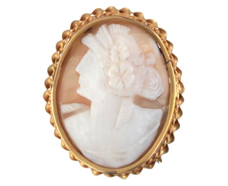 AN ANTIQUE CAMEO BROOCHin 12ct gold, set with a helmet shell, carved to depict the profile of a woman with flowers in her hai
