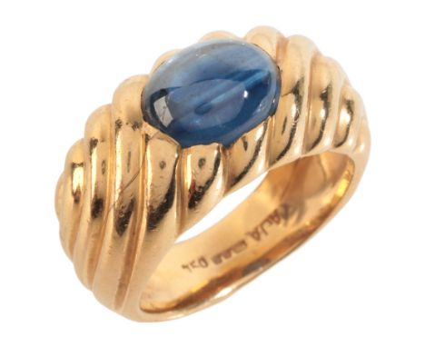 A SAPPHIRE DRESS RINGin 18ct gold, set with a sapphire cabochon of c.3.17 carats, over a stylised design, British import mark