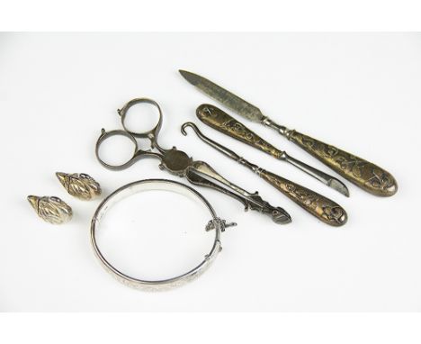 A selection of small silver wares, to include; a pair of George III silver sugar nips with shell shaped bowls, 11.5cm long, a