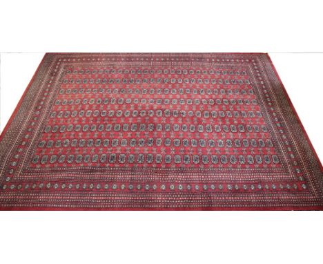 A Bokhara carpet, worked with rows of gulls against a red ground, 376cm x 280cm