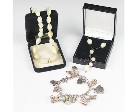 A silver charm bracelet with eleven attached charms and two padlocks, weight 66.8gms, along with two mother of pearl bead nec