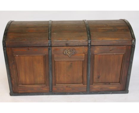 A stained pine dome top trunk, with carved and paper lined internal tray and twin brass handles, 60cm H x 102cm W x 57cm D