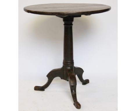 A George III provincial oak tilt top occasional table, with circular three section top, on a turned column and tripod base, 7