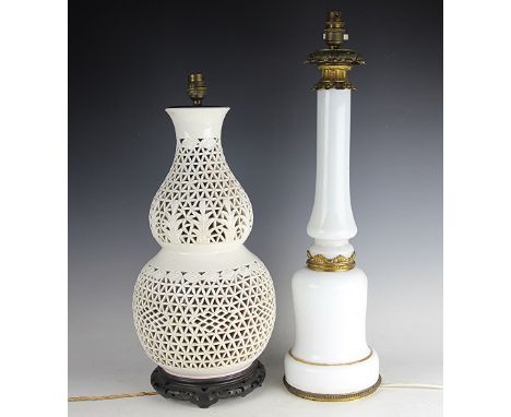 An opaque glass lamp base with gilt metal fittings, 60.5cm high and a Chinese blanc de chine lamp base, of double gourd form,