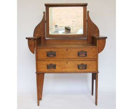 An Arts and Crafts oak dressing table, with mirror, above two drawers with Art Nouveau handles, on tall bracket feet, 138cm H