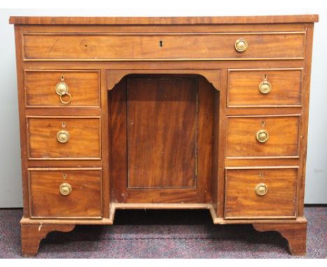 An Edwardian mahogany knee hole desk, the central door flanked by two six drawers and a long drawer, on bracket feet, 73cm H 