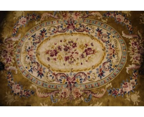 A large Chinese carpet, worked with a floral medallion against a mustard ground, 480cm x 357cm