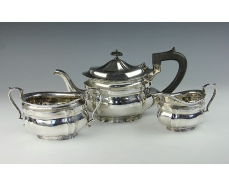 An Edwardian silver three piece tea service, of shaped oval form, with ebony finial and handle, Mappin & Webb, Sheffield 1908