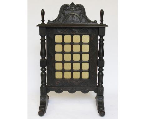 A Victorian carved and stained oak fire screen, with twenty glass panels, 110cm H x 71cm W