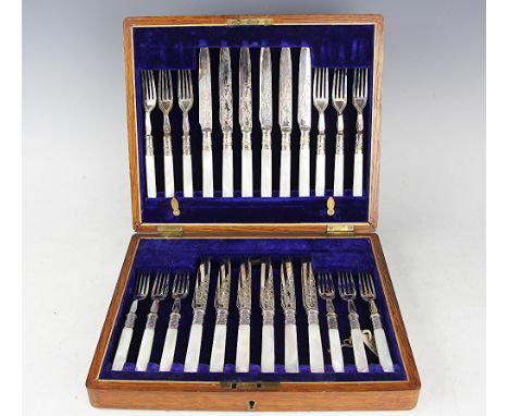 A Victorian set of twelve pairs of silver plated fruit knives and forks, with mother of pearl handles, in fitted golden oak c