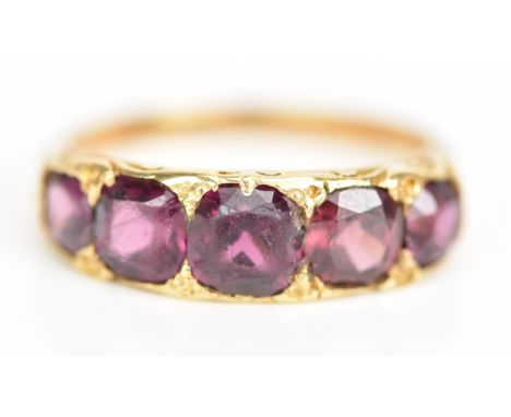 A Victorian yellow gold ring set with five faceted cut amethysts graduating in size, the largest approximately 5.8mm x 5.5mm,