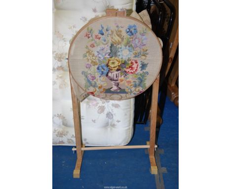 A circular tapestry stand, plus a floral tapestry that has been started.
