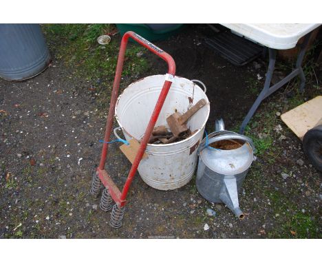A galvanised watering can and large enamel bin of various spanners, etc.