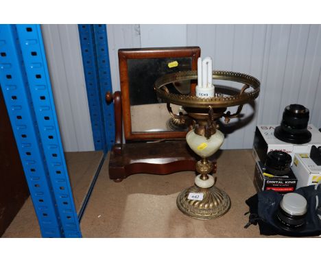 A swing framed toilet mirror together with a brass and onyx oil lamp converted to electricity