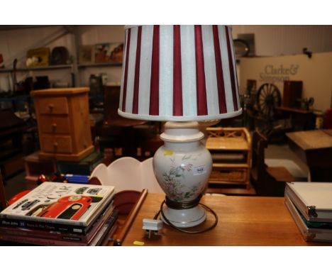 A floral decorated table lamp with striped shade 