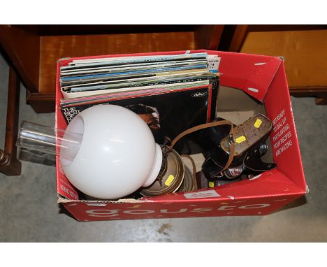 A box containing LPs, oil lamp with milk glass shade, Zenith camera etc.