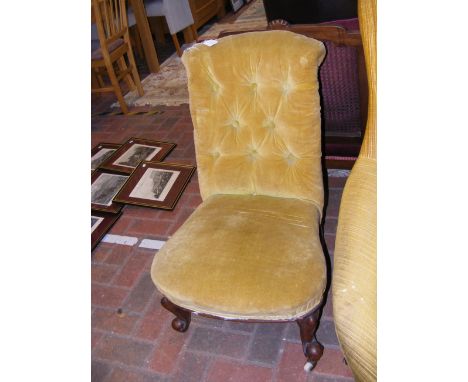 An antique button back nursing chair on castors 