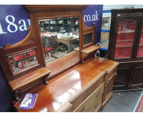 A late Victorian mahogany full height sideboard having arch crest and spindle mirror shelf top over frieze and central drawer