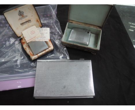 Two vintage cigarette lighters, a cigarette case and a white metal trinket box having naturalistic embossed decoration