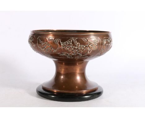 Art Nouveau style copper pedestal bowl with four repousse vignettes depicting Oriental scenes to include Kylin chasing flamin