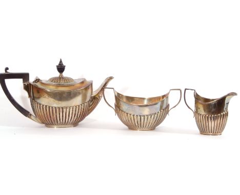 Bachelor's three piece silver tea service of oval form, half fluted bodies and angular handles, comprising tea pot with an eb