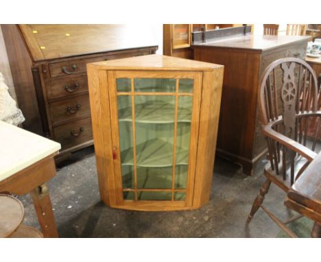 A light oak wall hanging corner cupboard in the manor of Ercol