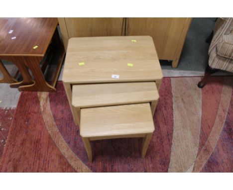 An Ercol nest of three light oak tables, the largest height 44 cm, the smallest 38 cm