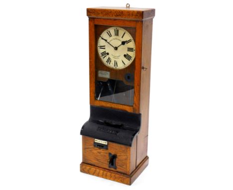 A National Time Recorder Company clocking in clock, the painted dial with Roman numerals in an oak case with bronzed iron fit