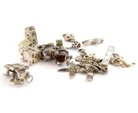 A small selection of silver and silver palted charms and pendants, comprising a carriage, a train, a silver boot, a chruch, a