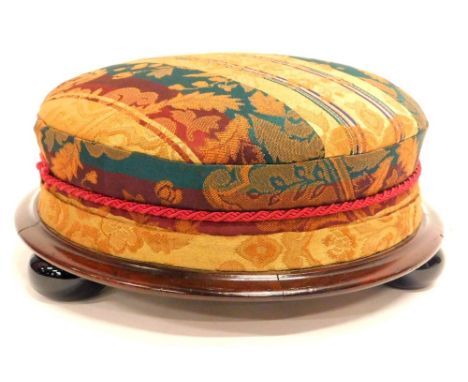 A Victorian mahogany footstool, with a padded seat, a moulded edge on black ceramic bun feet, 30cm diameter.