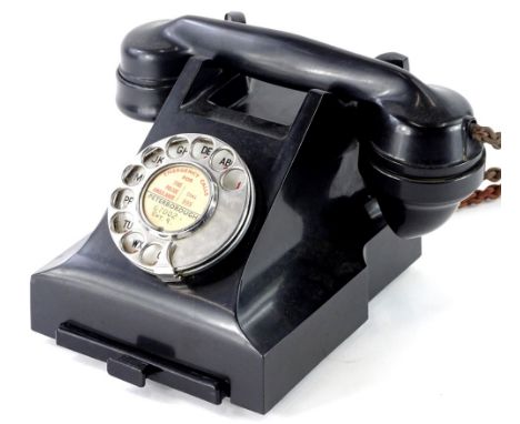 A black Bakelite vintage telephone,  with chrome dial with label for Peterborough, number to underside 332 F C55/1.