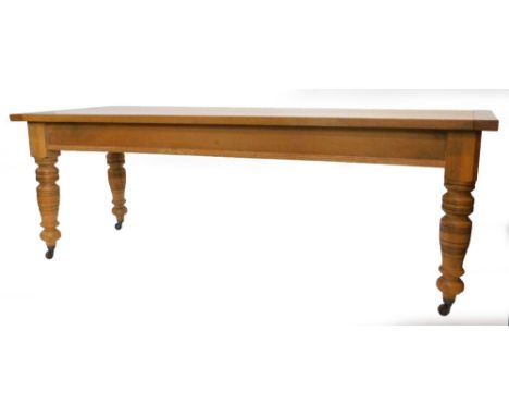An oak kitchen table, the planked and cleted top above a moulded frieze on turned tapering legs, with ceramic castors, 74cm h