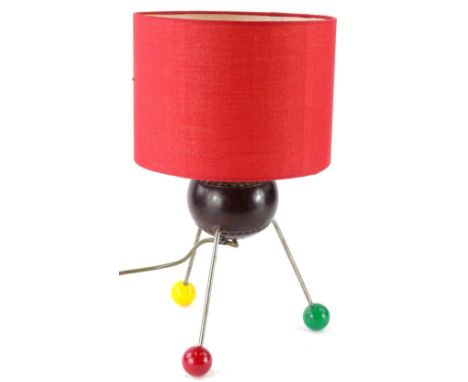 An unusual up-cycled table lamp, with a red shade, the body constructed from a bowling bowl and with steel and plastic atomic