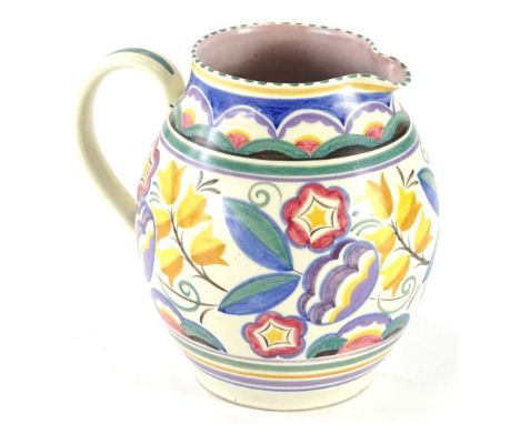 A Poole pottery jug, decorated in typical fashion with flowers and leaves in yellow, blue, green, red, purple, etc., impresse