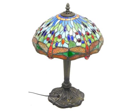 A Tiffany style table lamp, the stained glass shade decorated with dragonflies, the gilt bronzed spelter base, also decorated