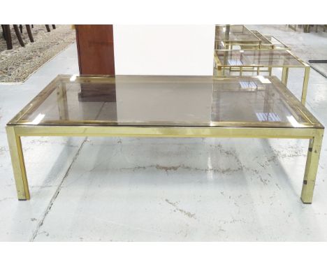 LOW TABLE, vintage 1970s, gilt metal with a smoked glass, 130cm W x 60cm D x 40cm H, along with a nest of three tables, smoke
